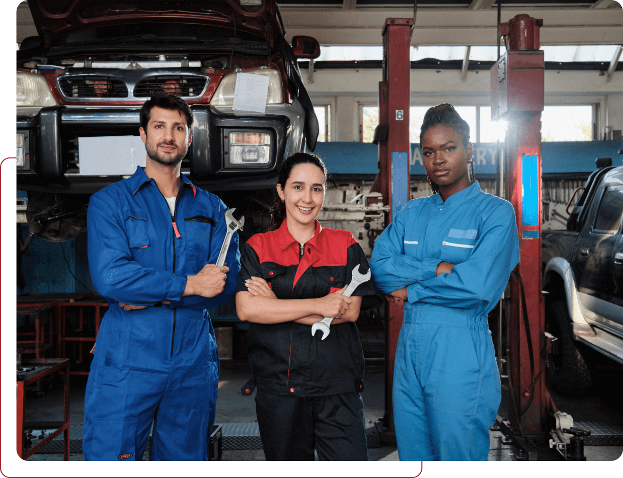 Auto mechanics posing in a garage workshop.