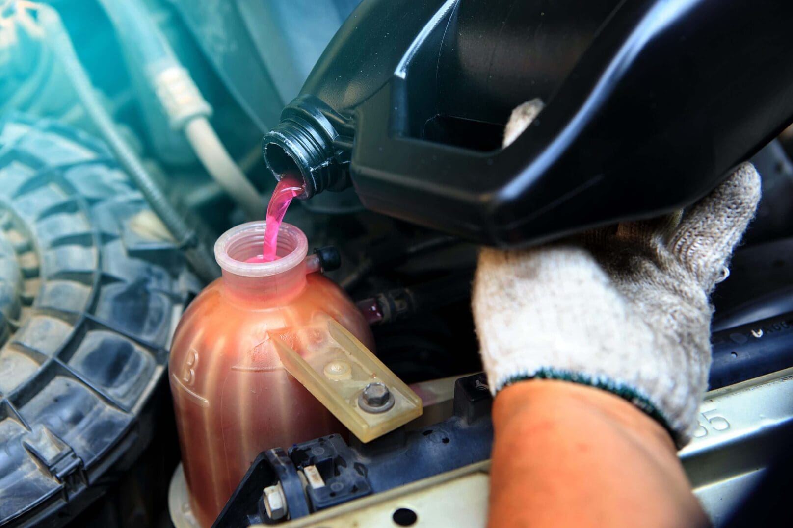 A person pouring oil into a motorcycle engine.